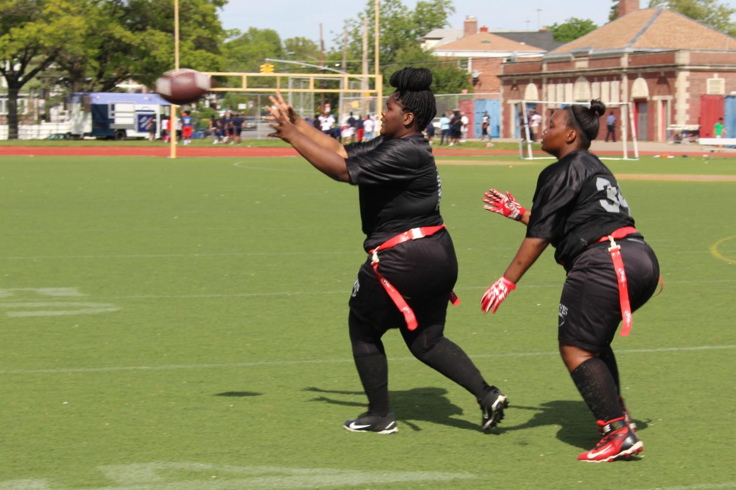 Paola Green and Christina Walker Robinson, both students at Francis Lewis High School, play in a flag football game