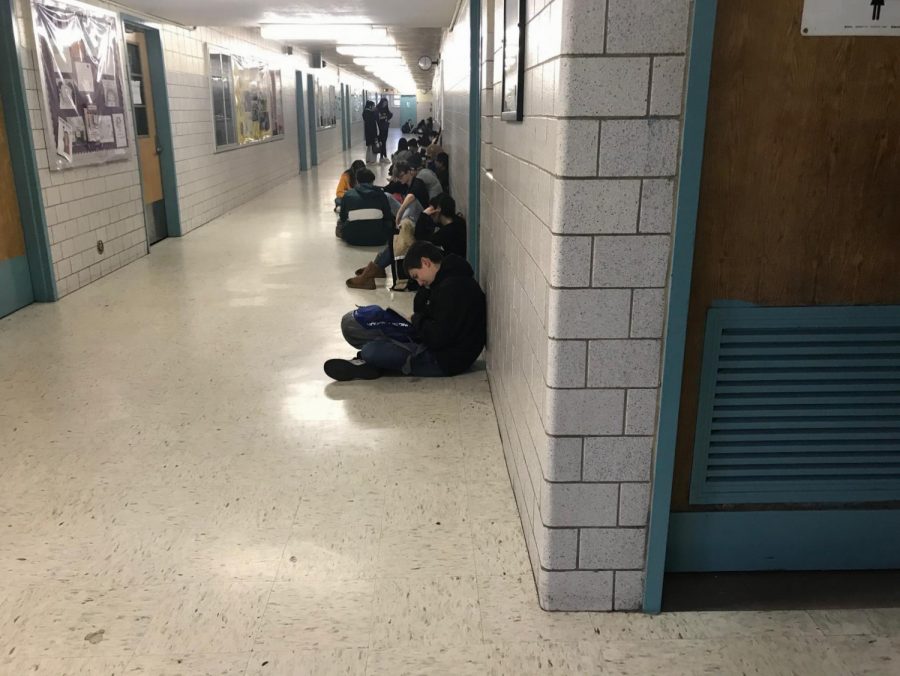 Students sitting in the hallway on the second floor. 