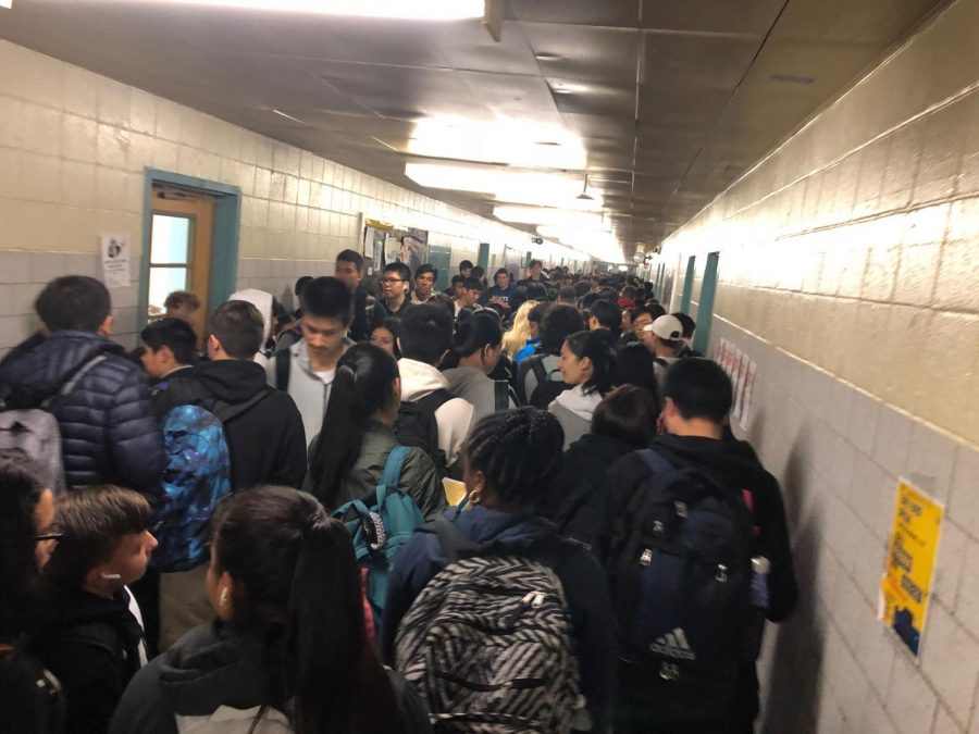 The students are moving through the crowded hallway during in between period 7 and period 8