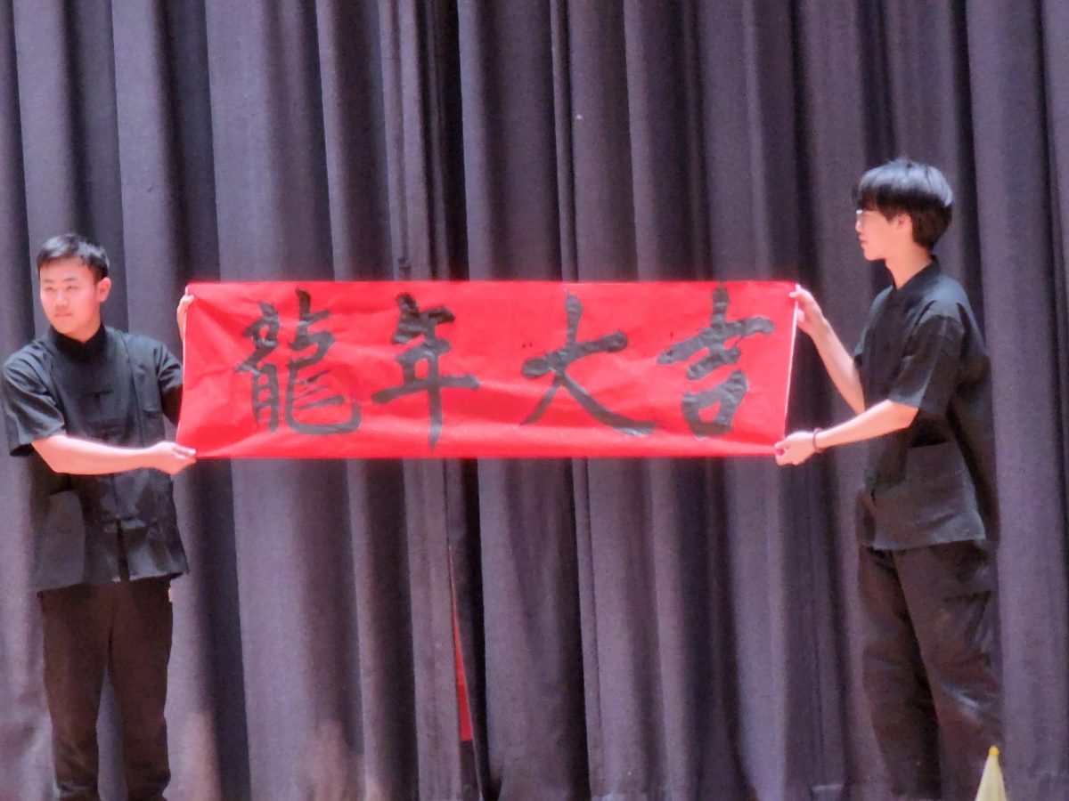 Chinese language students holding a banner meaning “Good luck in the Year of the Dragon“