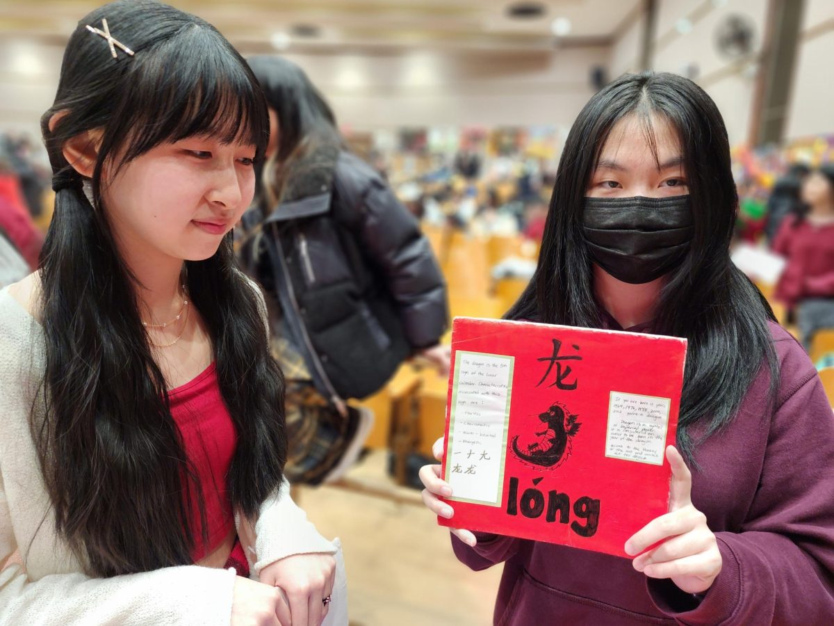 Chinese language students holding a sign showing “Dragon”, which is this year’s Chinese Zodiac.