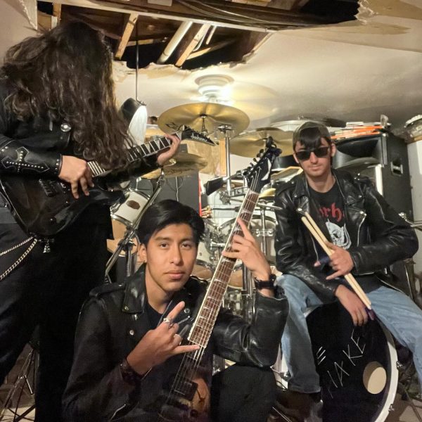 The trio (Mateo, Angel, and John) stands with their instruments.