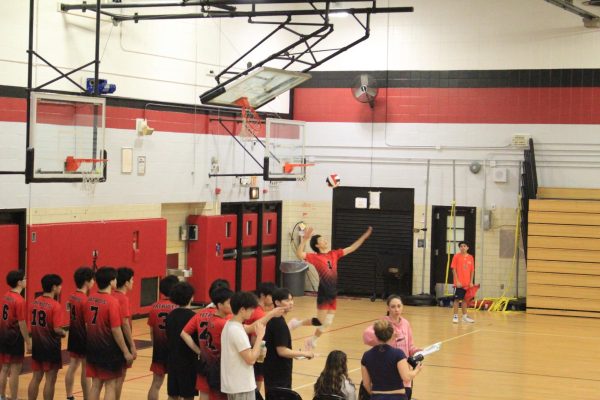 Senior Wai Jian Lai serving against Cardozo High School on April 9.